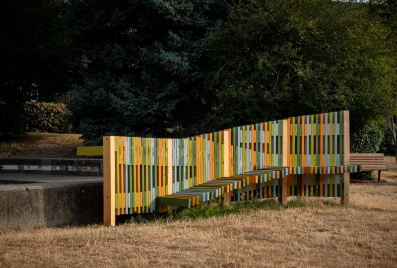 Finished central panel of fence and seating structure with colorful wood