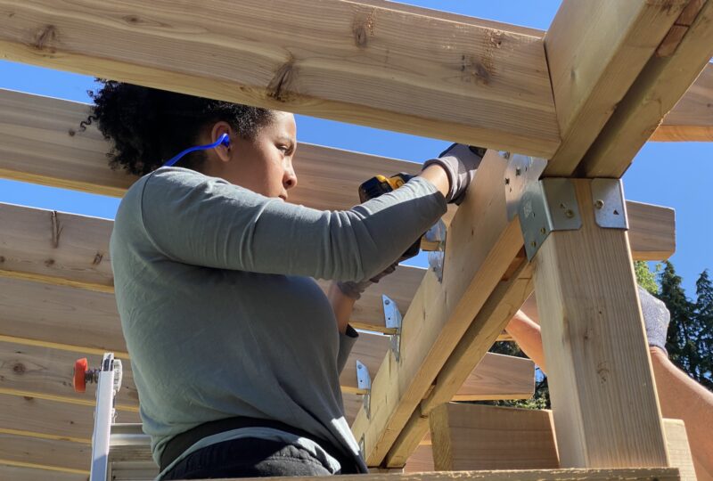 student on ladder driving in screws